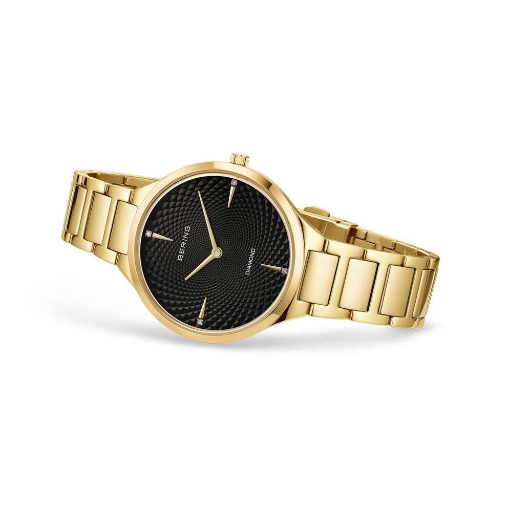 Orologio da polso dorato con quadrante nero strutturato e bracciale abbinato, presentato da angolazione tre-quarti.