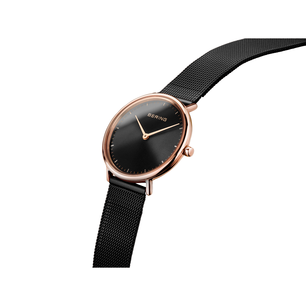 BERING wristwatch, rose gold case, black dial, black mesh strap, side angle view