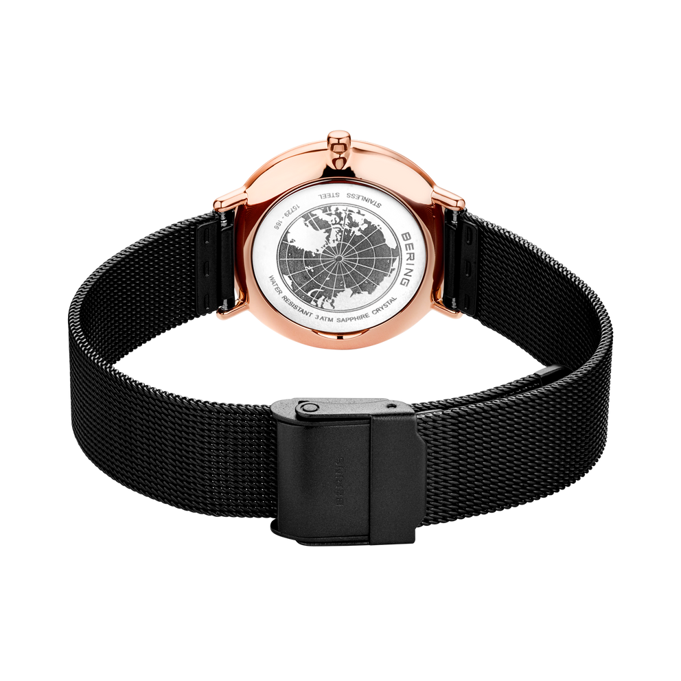 Wristwatch with rose gold case and black mesh band, dial visible in center, rear view