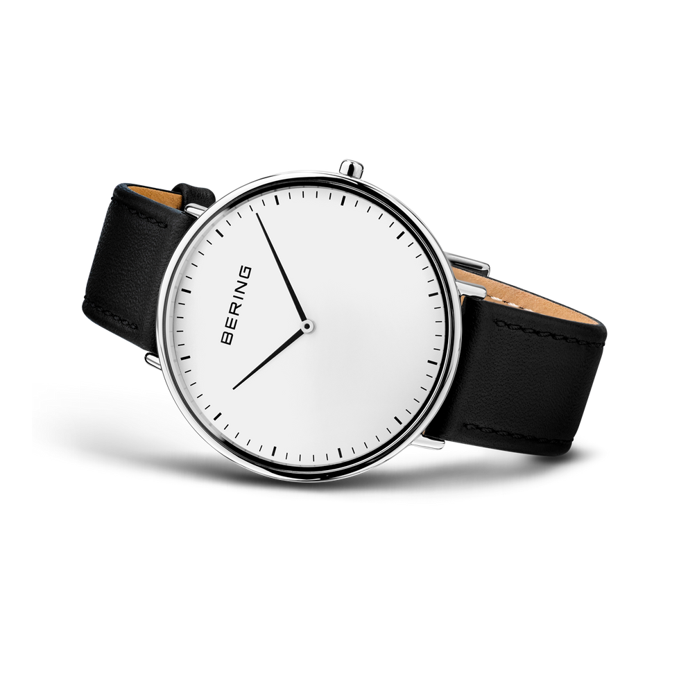 BERING ur med minimalistisk hvidt urskive, sort læderarmbånd og bronzedetaljer, sidevinkel