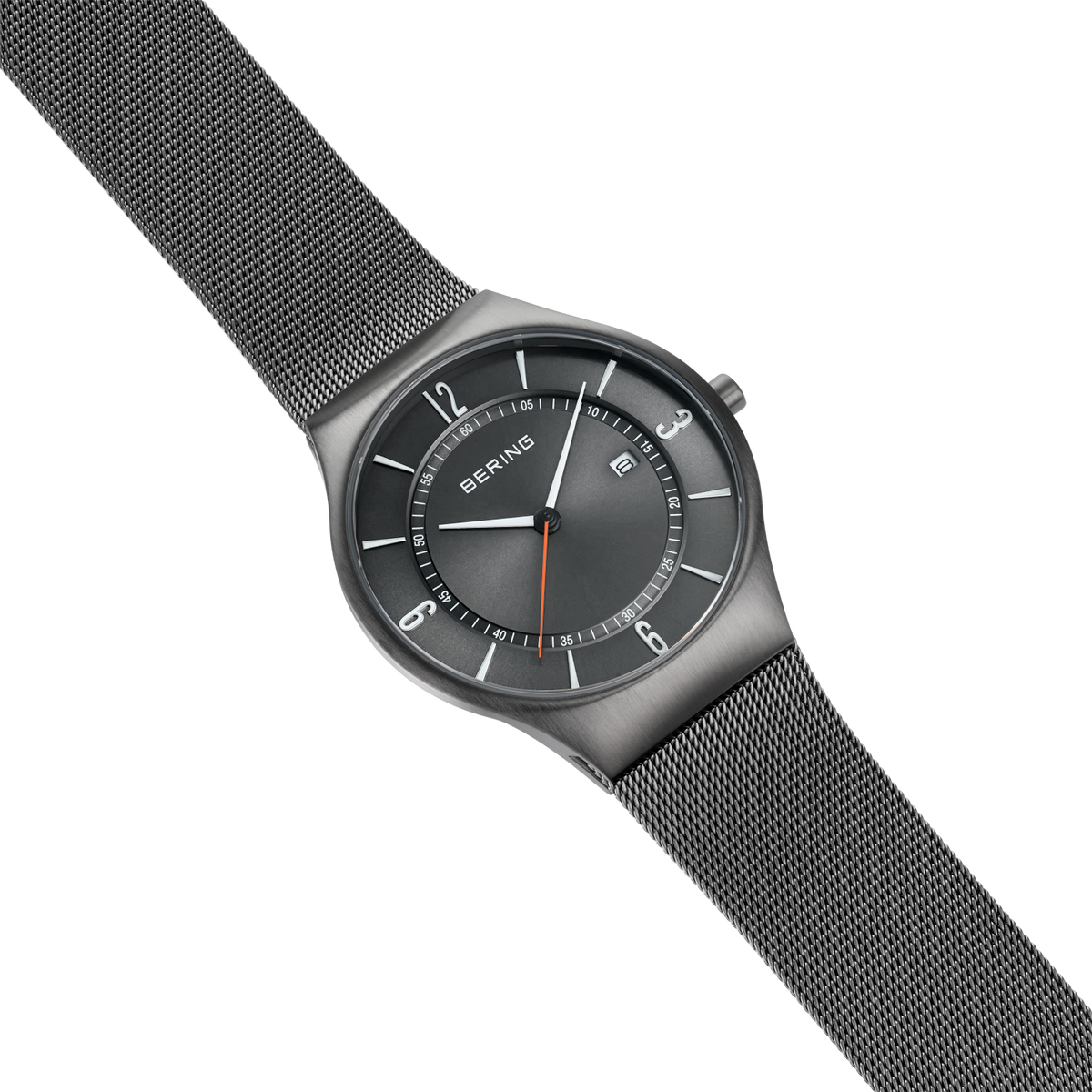 Montre-bracelet BERING avec cadran foncé, design minimaliste et bracelet maille gris en vue diagonale