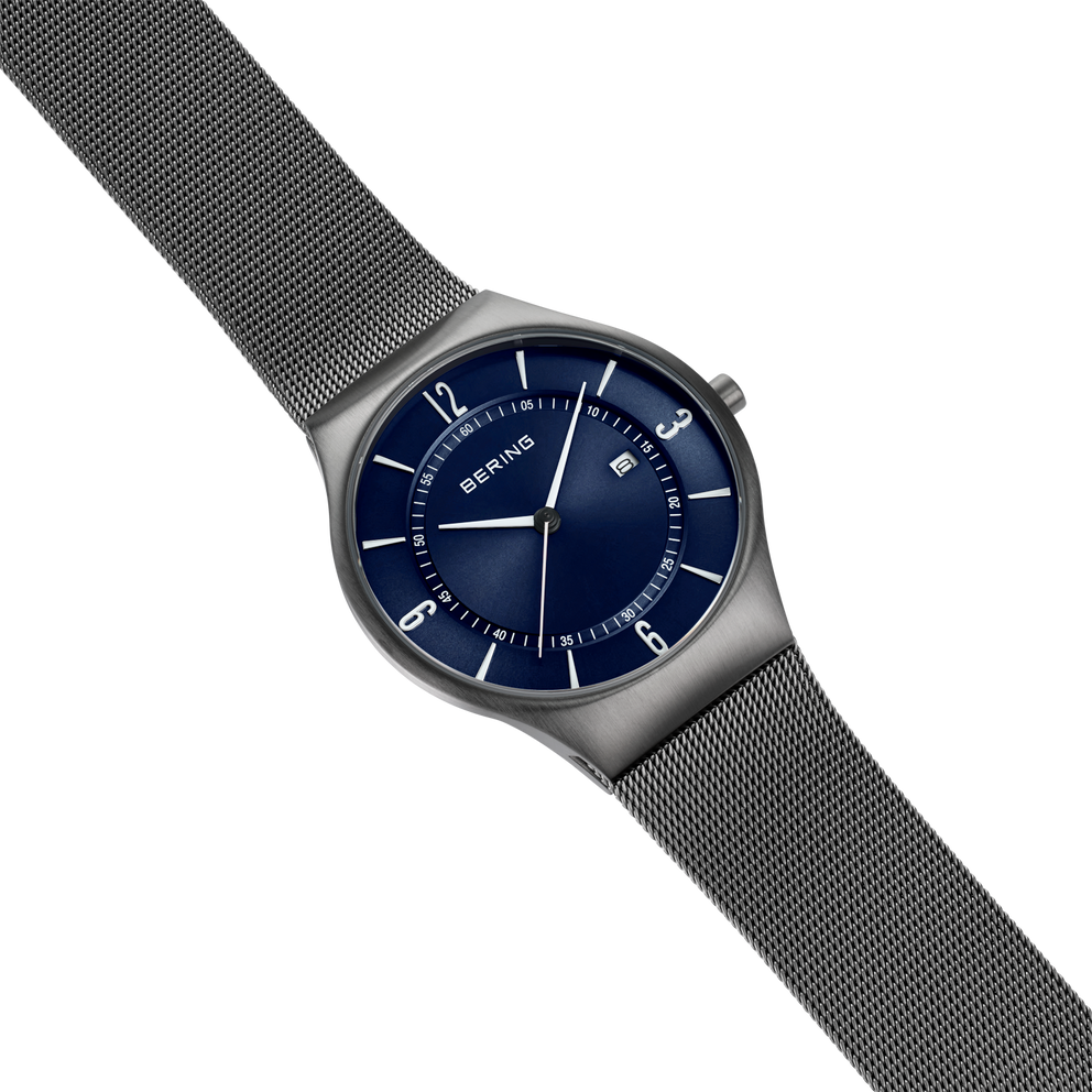 Reloj BERING con esfera azul marino, correa de malla plateada, vista de perfil