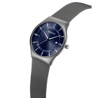 Reloj de pulsera con esfera azul oscuro, agujas e índices plateados, y pulsera de malla gris de acero, en vista de ángulo.
