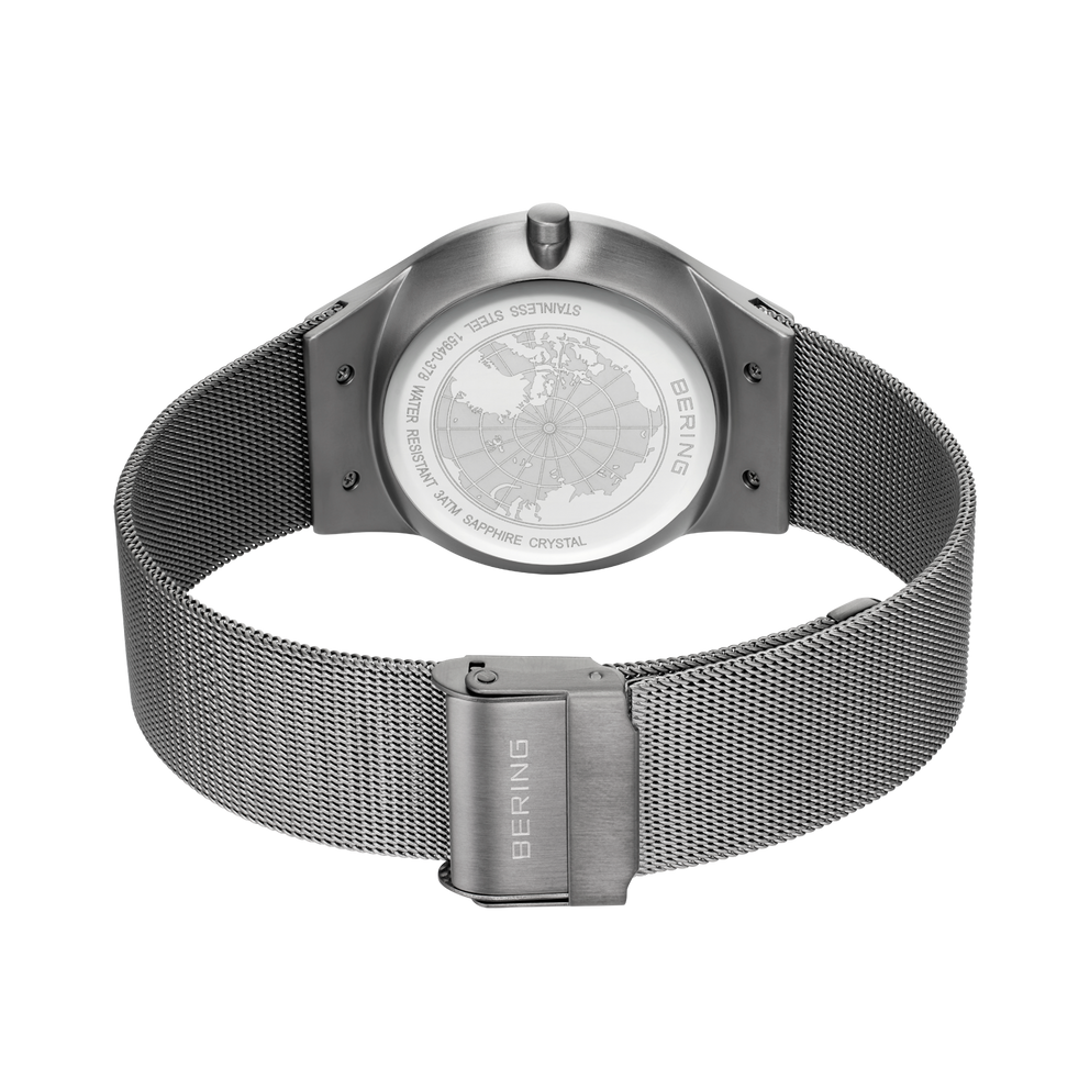 Reloj con pulsera de malla plateada, vista trasera mostrando el fondo