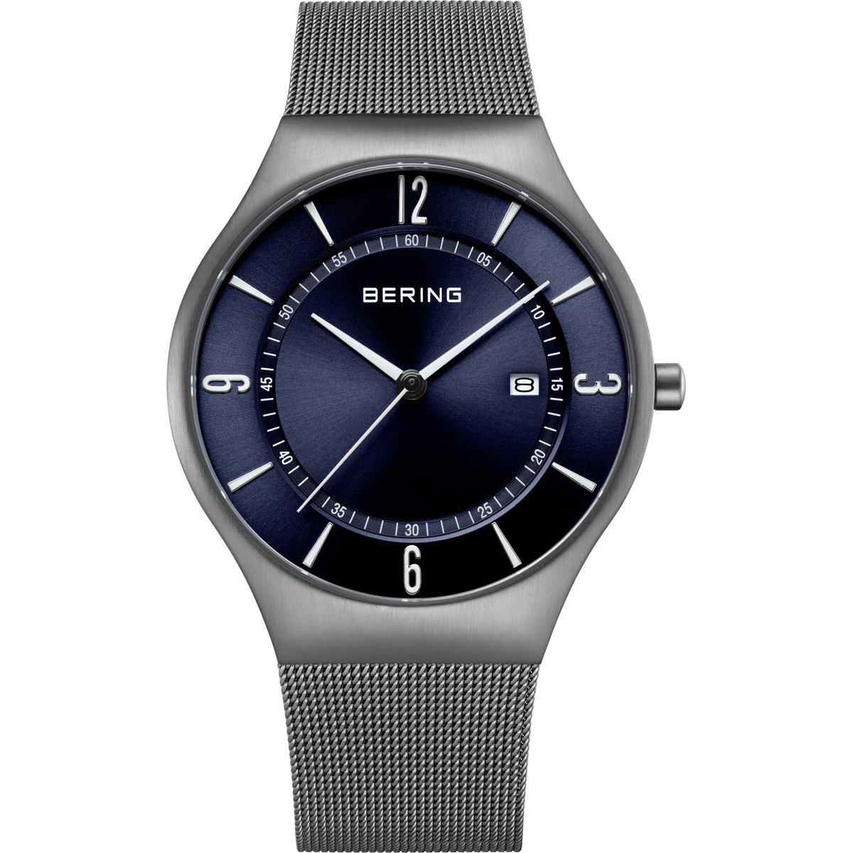 Reloj con pulsera de malla plateada, esfera azul marino, manecillas blancas e índices horarios, ventana de fecha