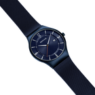 BERING wristwatch with dark blue dial and black case, displayed at angle with dark blue mesh strap against light blue background.