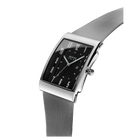 Rectangular silver wristwatch with black dial, angled to show mesh metal band and side profile.