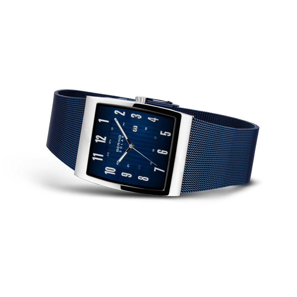 BERING wristwatch in angled side view: square blue dial with white markers, silver metal case, blue mesh strap