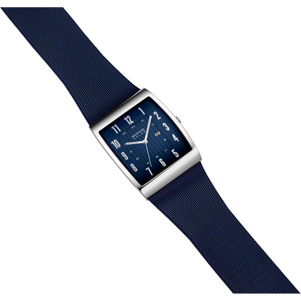 Square-faced BERING watch with silver case, dark blue dial, Arabic numerals, and navy fabric strap