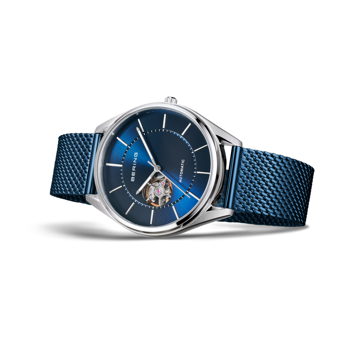 Watch with silver case, dark blue dial with white markers, and blue textile strap, side view showing transparent center