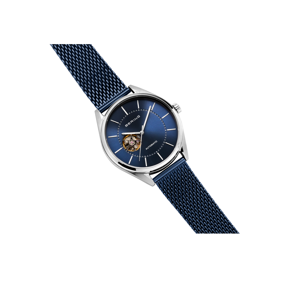 BERING wristwatch 16743-307, blue skeleton dial with visible movement, silver case and navy mesh strap, angled detail view