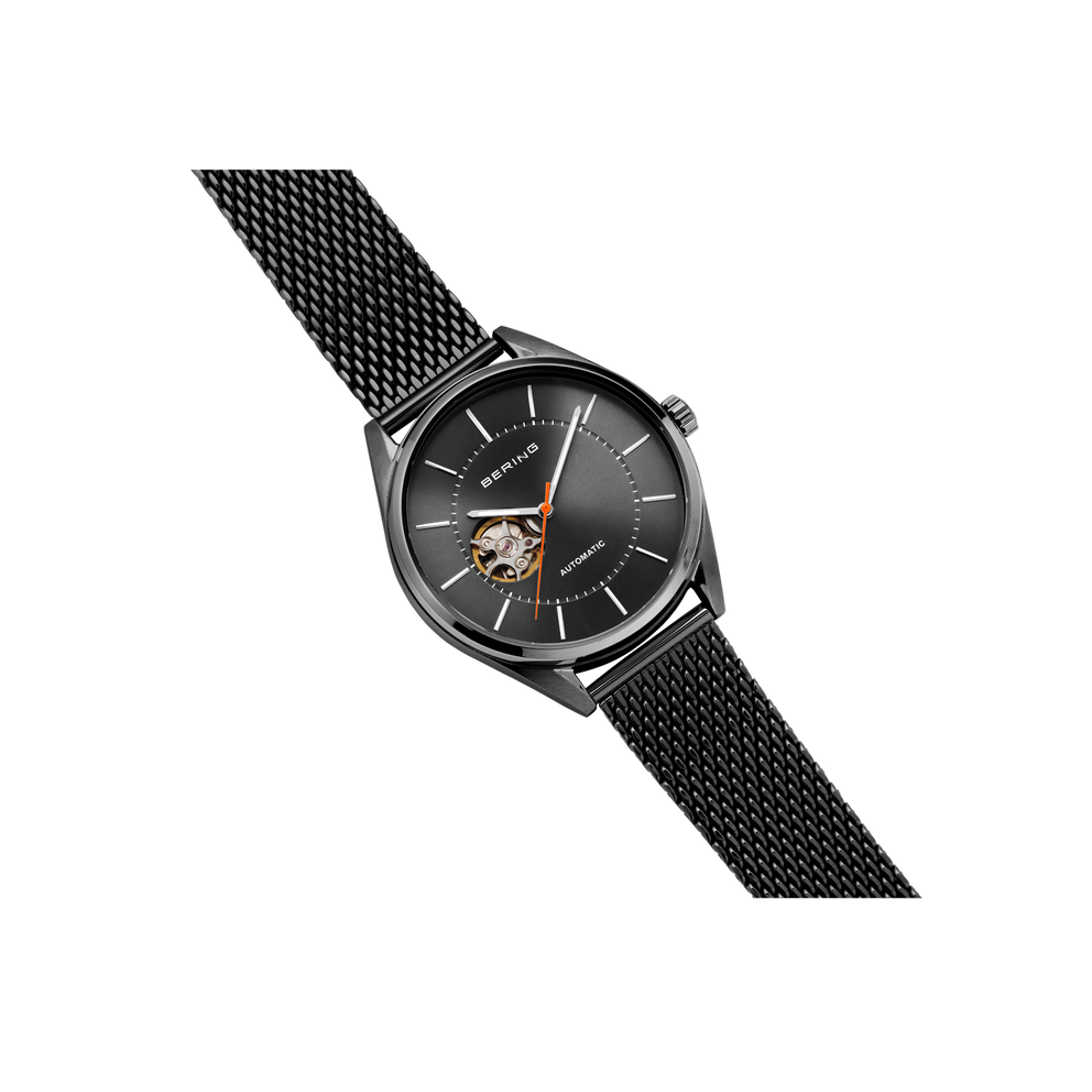 Black BERING wristwatch with mesh band, angled view showing open-heart dial