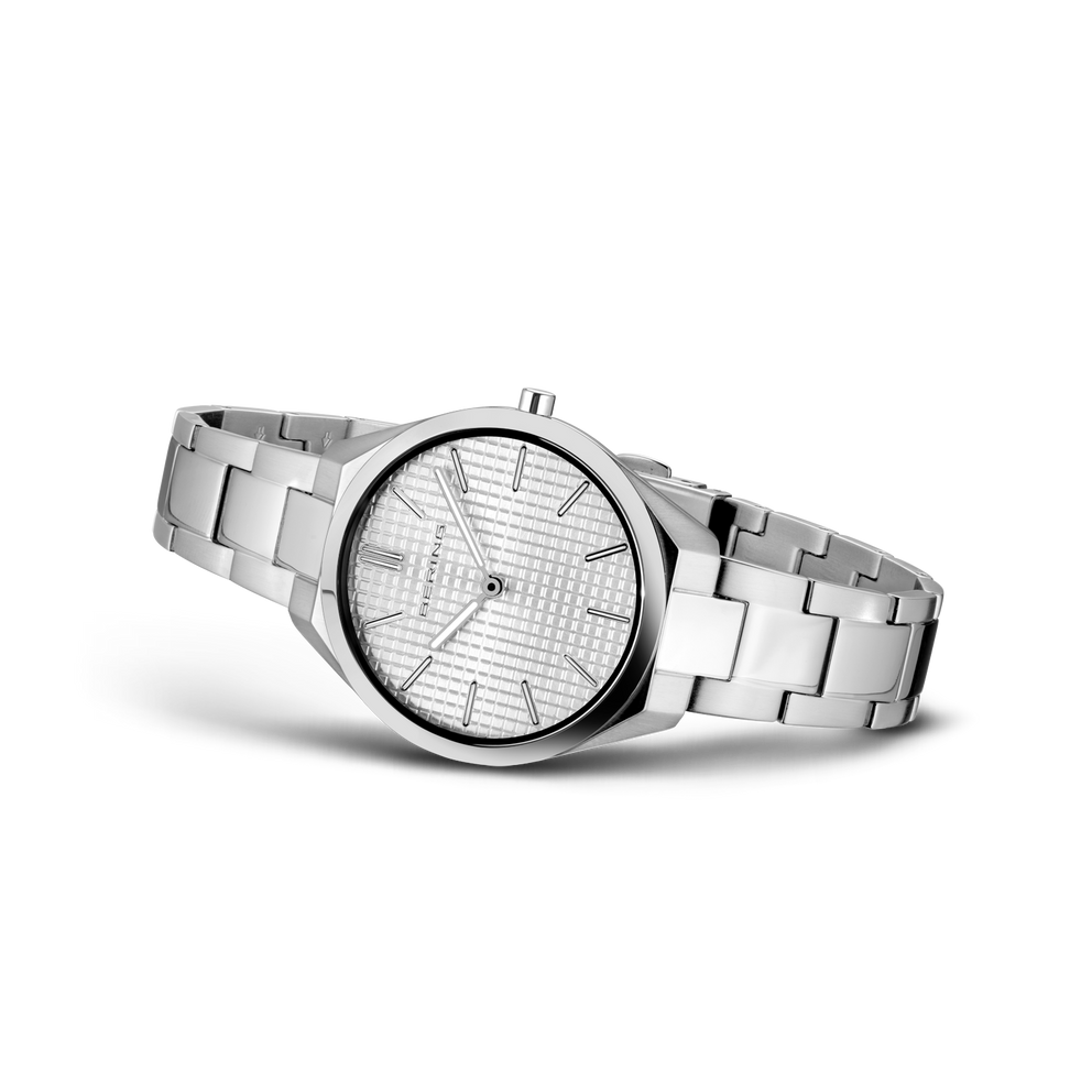 Sølvfarvet metalarmbandsur med rund urskive og sort bezel, set fra siden.