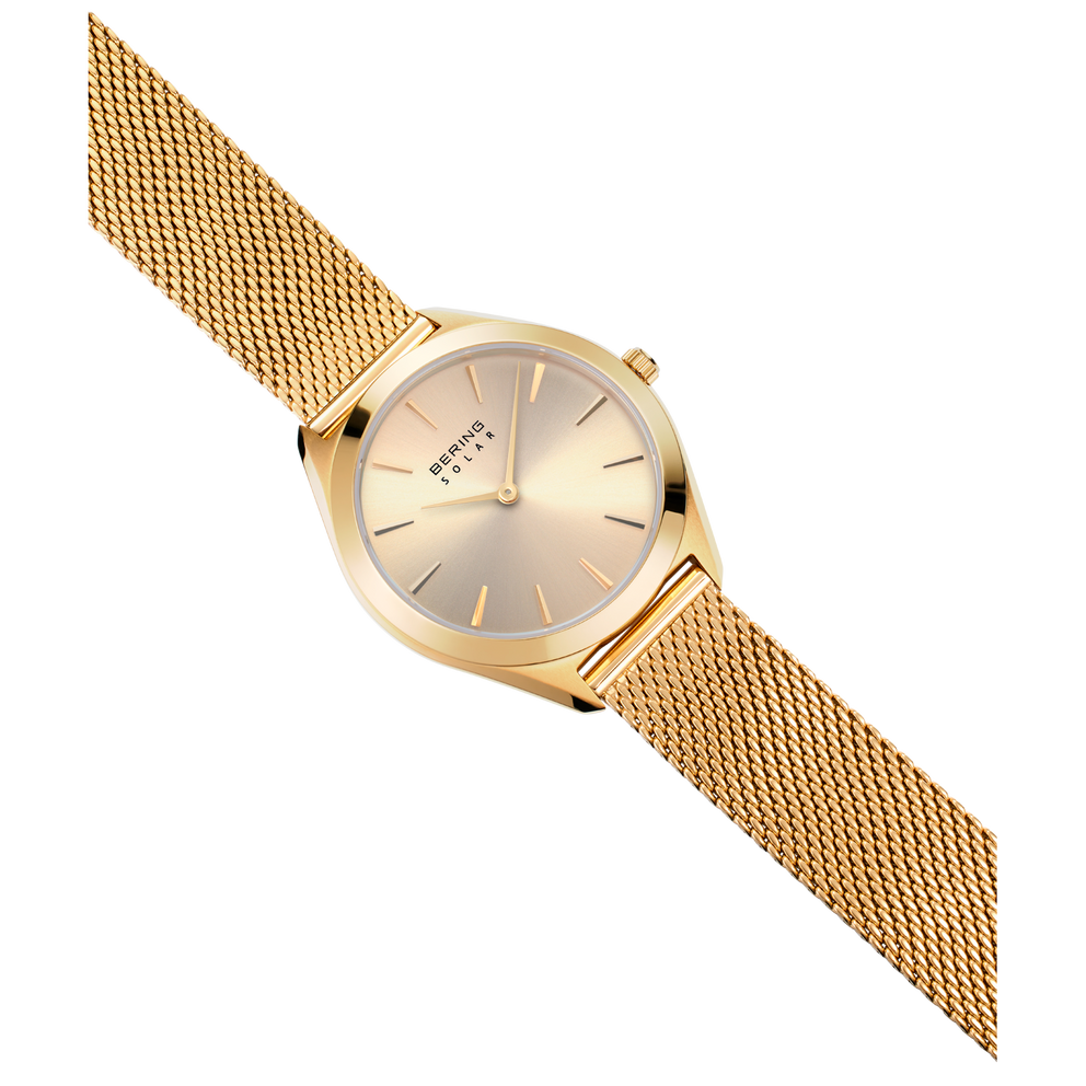 Orologio dorato con cinturino a maglia in vista angolata, cinturino metallico strutturato e quadrante minimalista