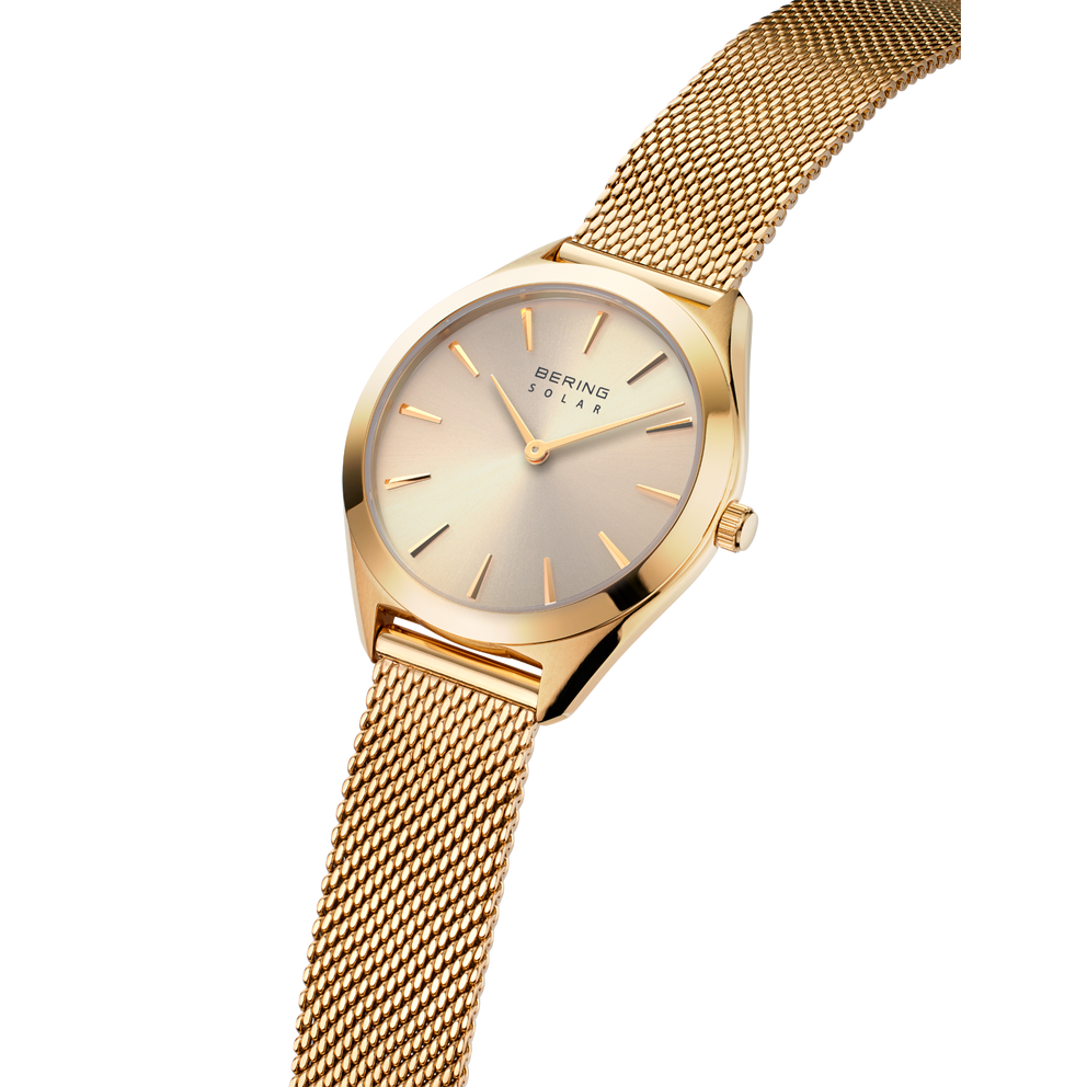 Orologio BERING con braccialetto a maglia dorato e quadrante crema, vista laterale della struttura di braccialetto e cassa