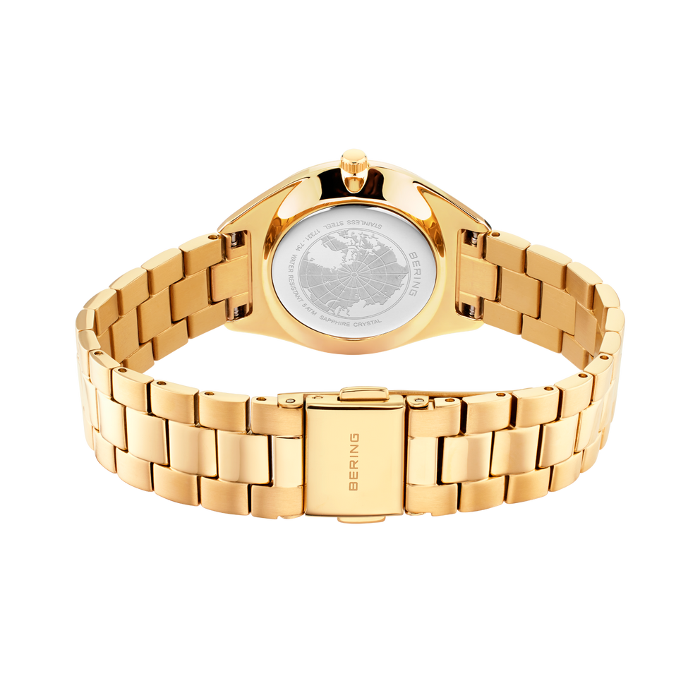Orologio da polso color oro visto dal retro, con fondello bianco visibile e cinturino in metallo