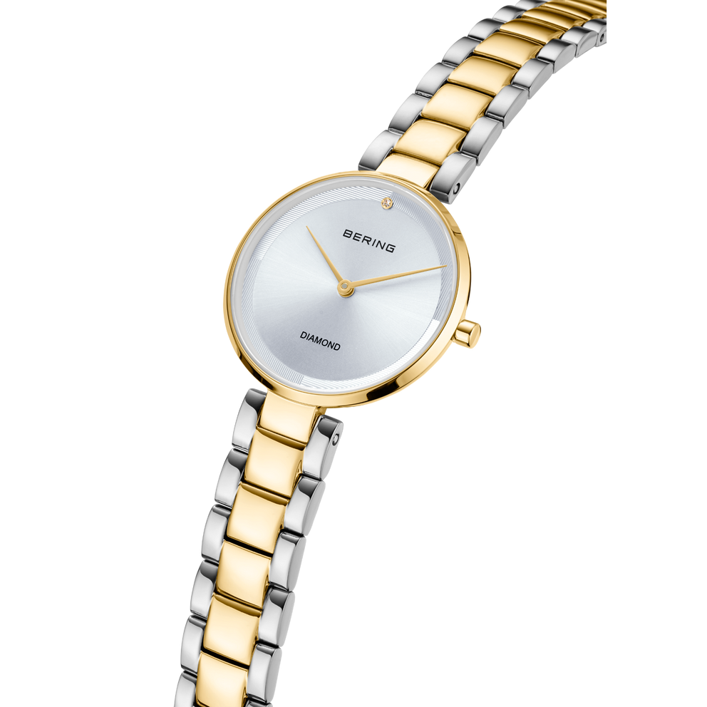 BERING wristwatch angled view showing two-tone silver and gold bracelet, white dial, and minimalist design.