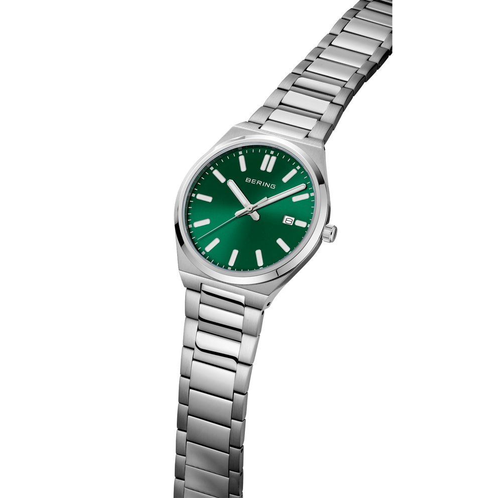 Steel watch with green dial and three-hand movement, angled view highlighting the metal link bracelet.
