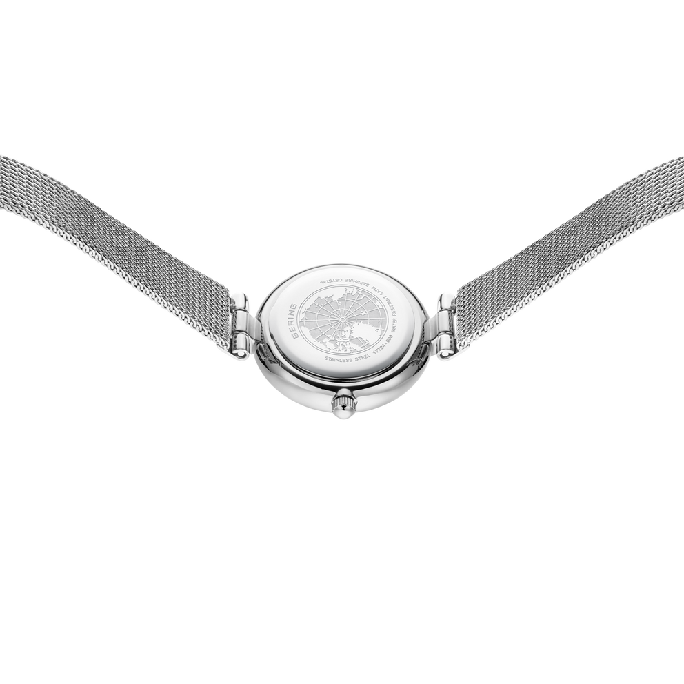 Round chrome watch case with mesh metal bracelet, top-down view.