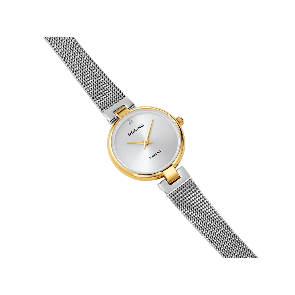 BERING 17724-010 wristwatch with silver dial, gold case and gray mesh band, angled view.