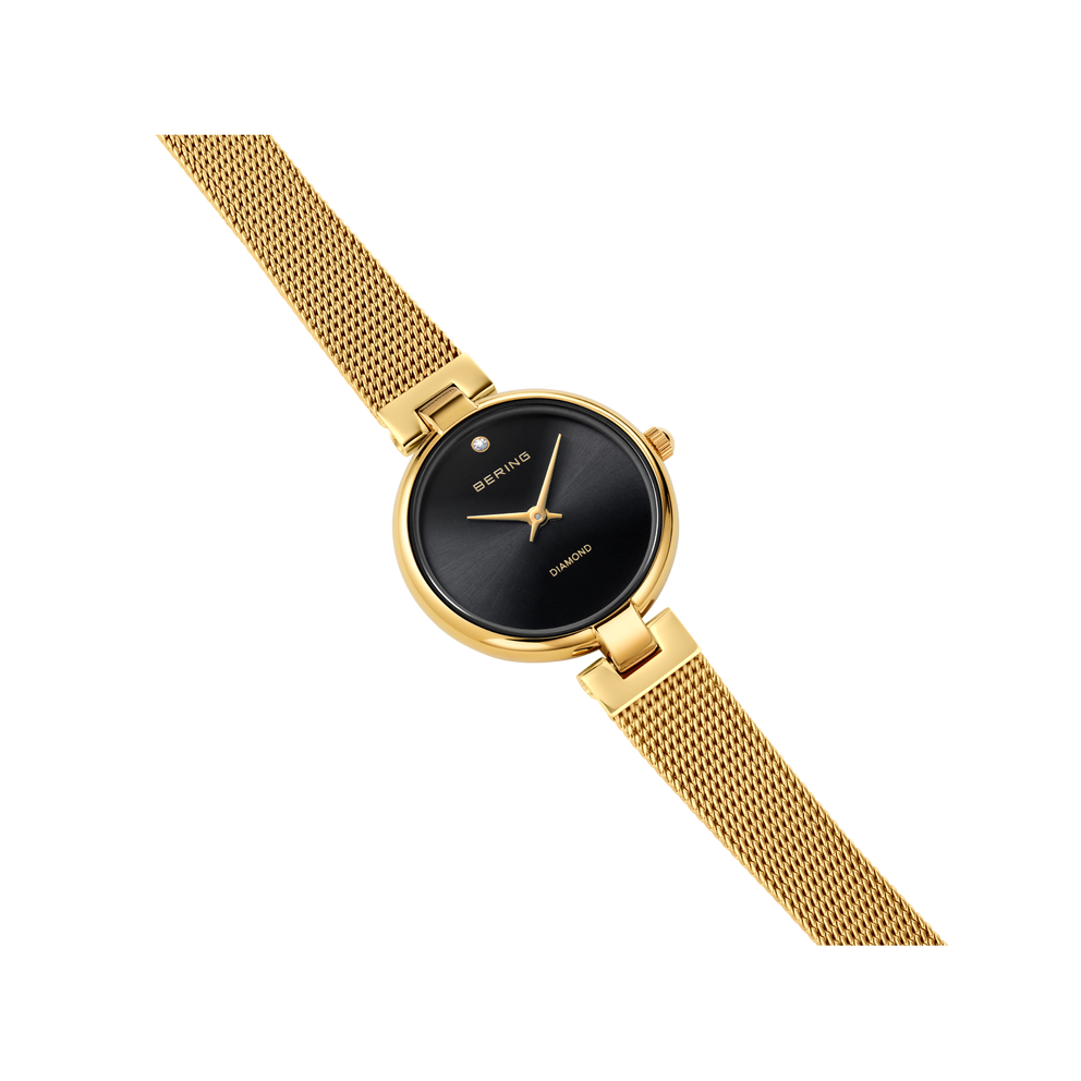 Goudkleurig mesh-armbanduhr met zwarte wijzerplaat en fijne uurmarkeringen, diagonaal weergegeven