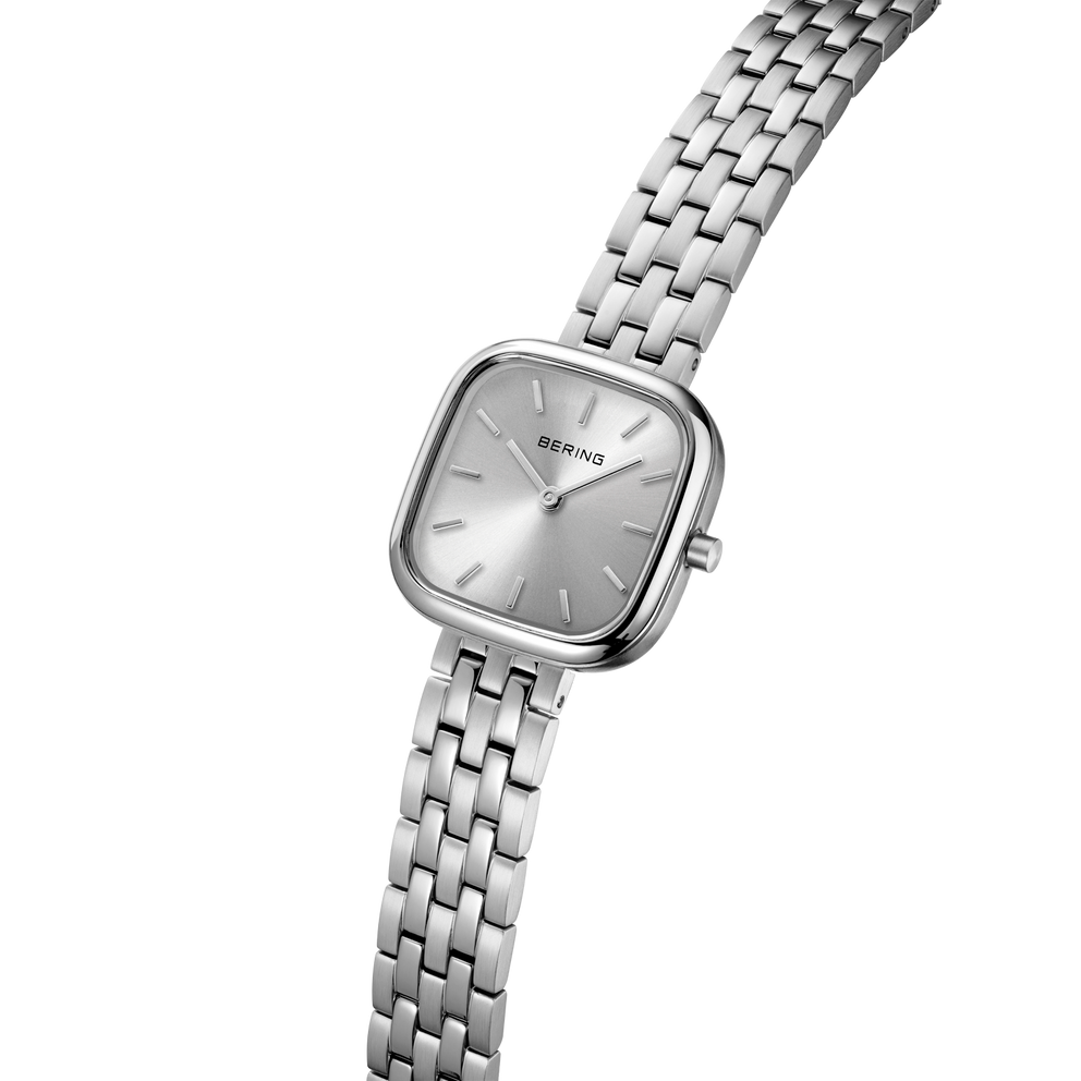 Montre carrée argent avec boîtier poli et bracelet à mailles métalliques en perspective angulée