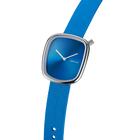 Square watch with blue dial, silver case, and blue textile strap