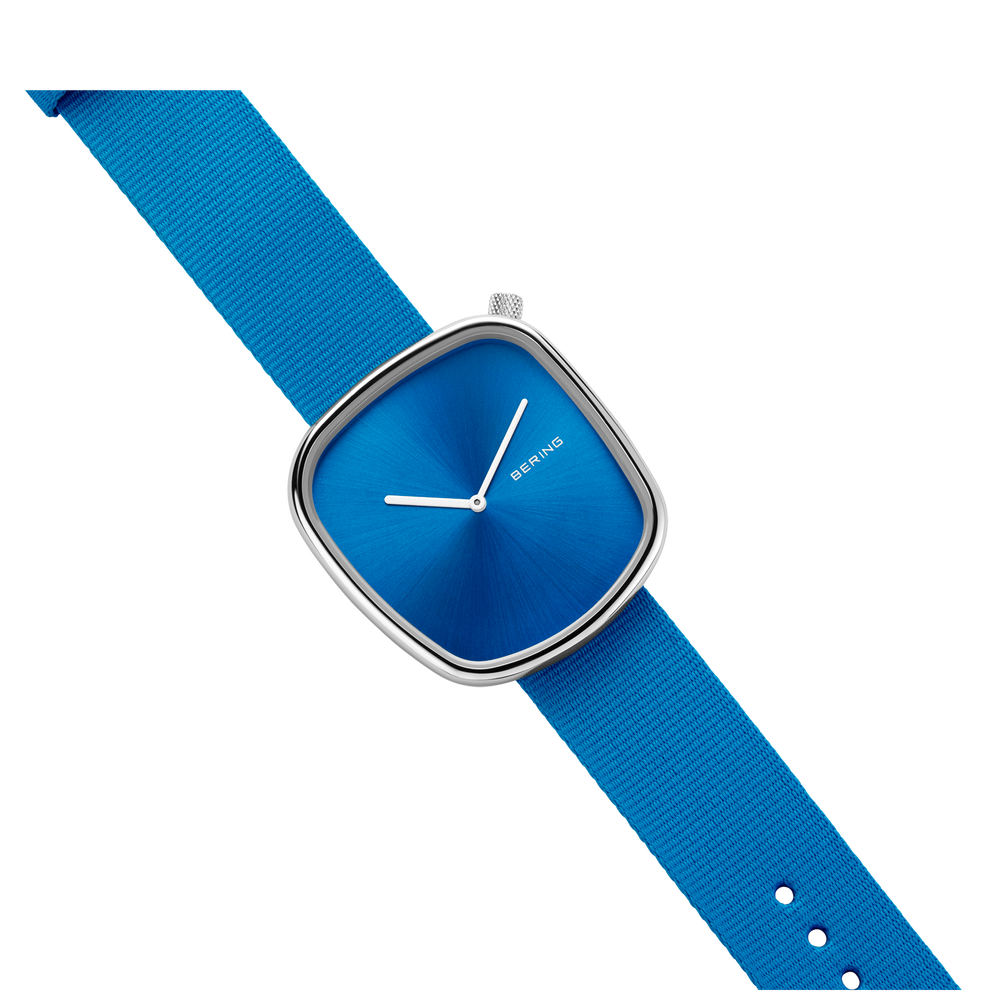 Square-cased BERING wristwatch with blue dial, blue fabric strap shown at an angle