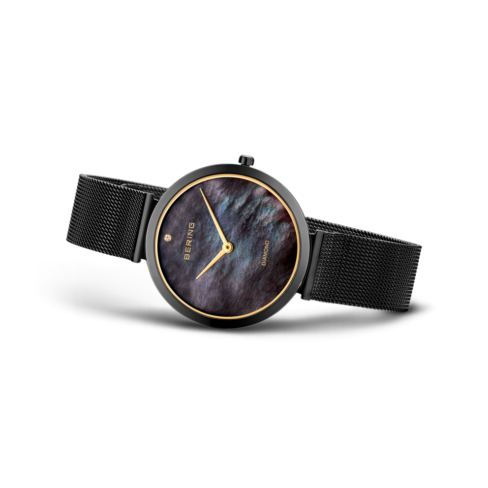 Reloj en vista lateral con correa de malla oscura, esfera azul oscuro con números romanos y manecillas doradas.