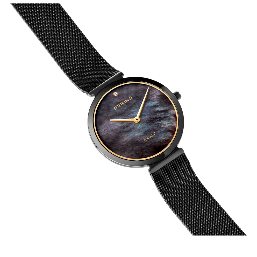 Reloj redondo con esfera oscura marmorizada, caja y agujas doradas, pulsera malla negra, vista angular.