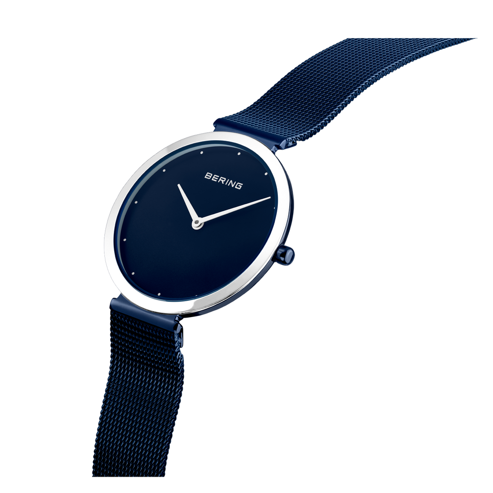 BERING horloge met donkerblauwe wijzerplaat, eenvoudige wijzers en marineblauw stofbandje, schuin gefotografeerd.