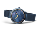 Esfera azul oscuro con agujas doradas y marcadores de hora, pulsera malla oscura