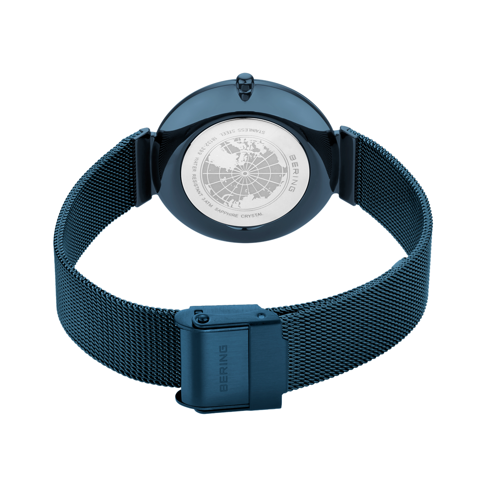 Reloj con pulsera malla azul, esfera brújula blanca y calavera en la corona, vista superior