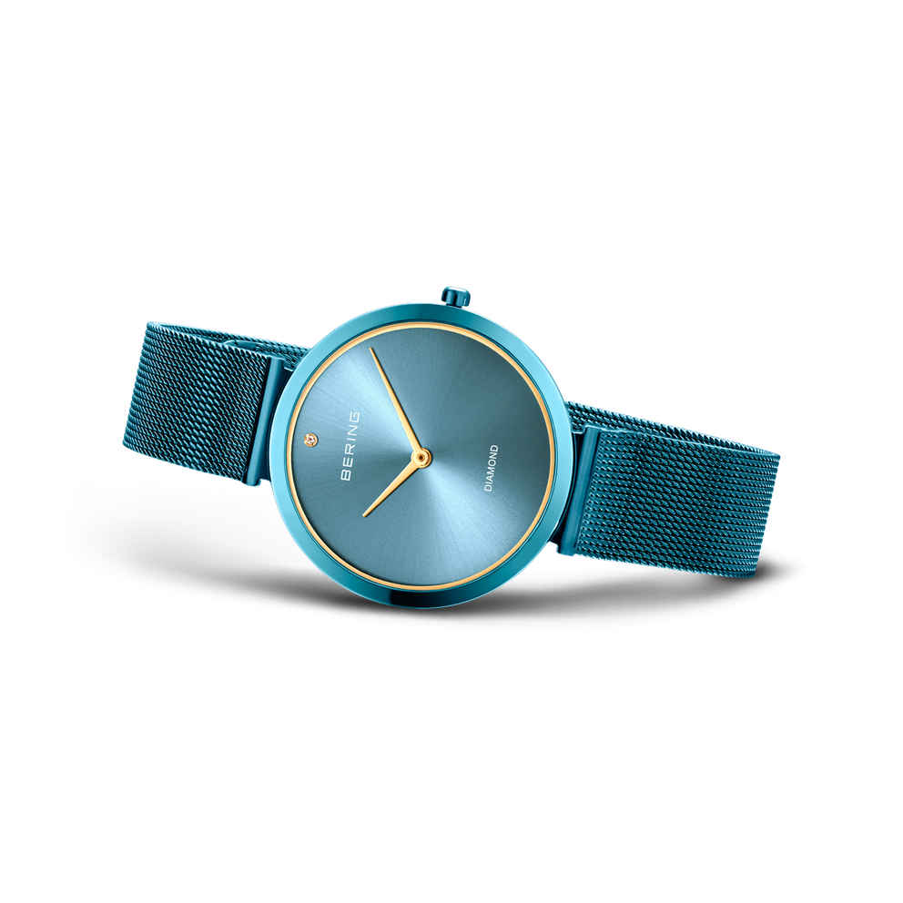 BERING Charity1-horloge met turquoise mesh-band, rond geval en grijsblauw wijzerplaat met gouden wijzers.