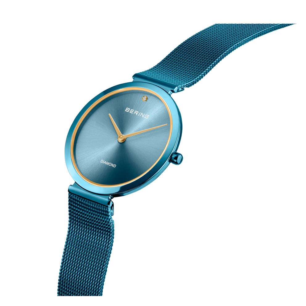 BERING Charity1-horloge met teal mesh-band, rond behuizing en goudkleurige wijzers.