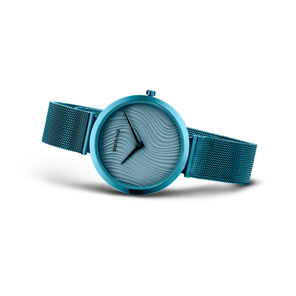 Turquoise watch with mesh band, textured dial and three hands from three-quarter angle