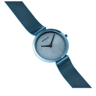 Light blue circular watch with mesh band, photographed at angle with minimalist striped dial.