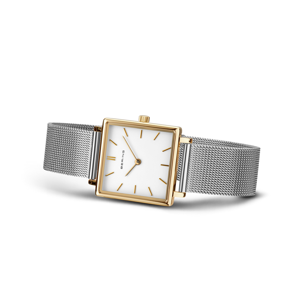 Square-cased wristwatch with rose gold accents, white dial, black hour markers, and gray mesh band.