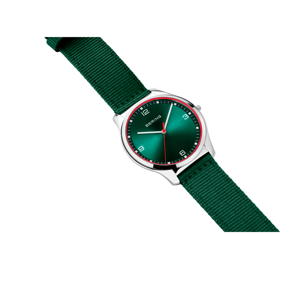 BERING wristwatch with teal dial and silver case, dark green ribbed fabric strap, angled view