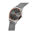 Wristwatch with dark dial, orange accent ring, and silver mesh band, displayed at angle showing face and strap.