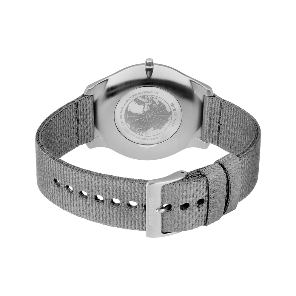 Stainless steel wristwatch with textured mesh band shown from the back, revealing the band's construction and fit.
