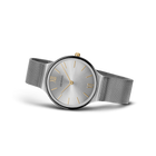 Round gray dial with silver hour markers and gold hands. Mesh metal band extending from both sides.
