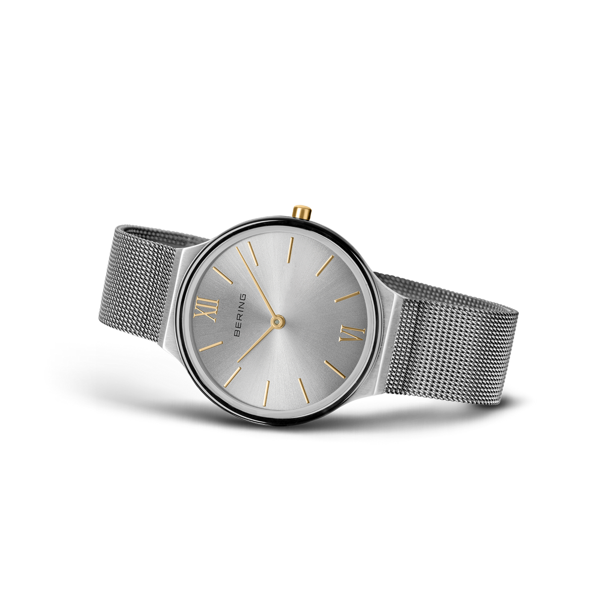 Round gray dial with silver hour markers and gold hands. Mesh metal band extending from both sides.