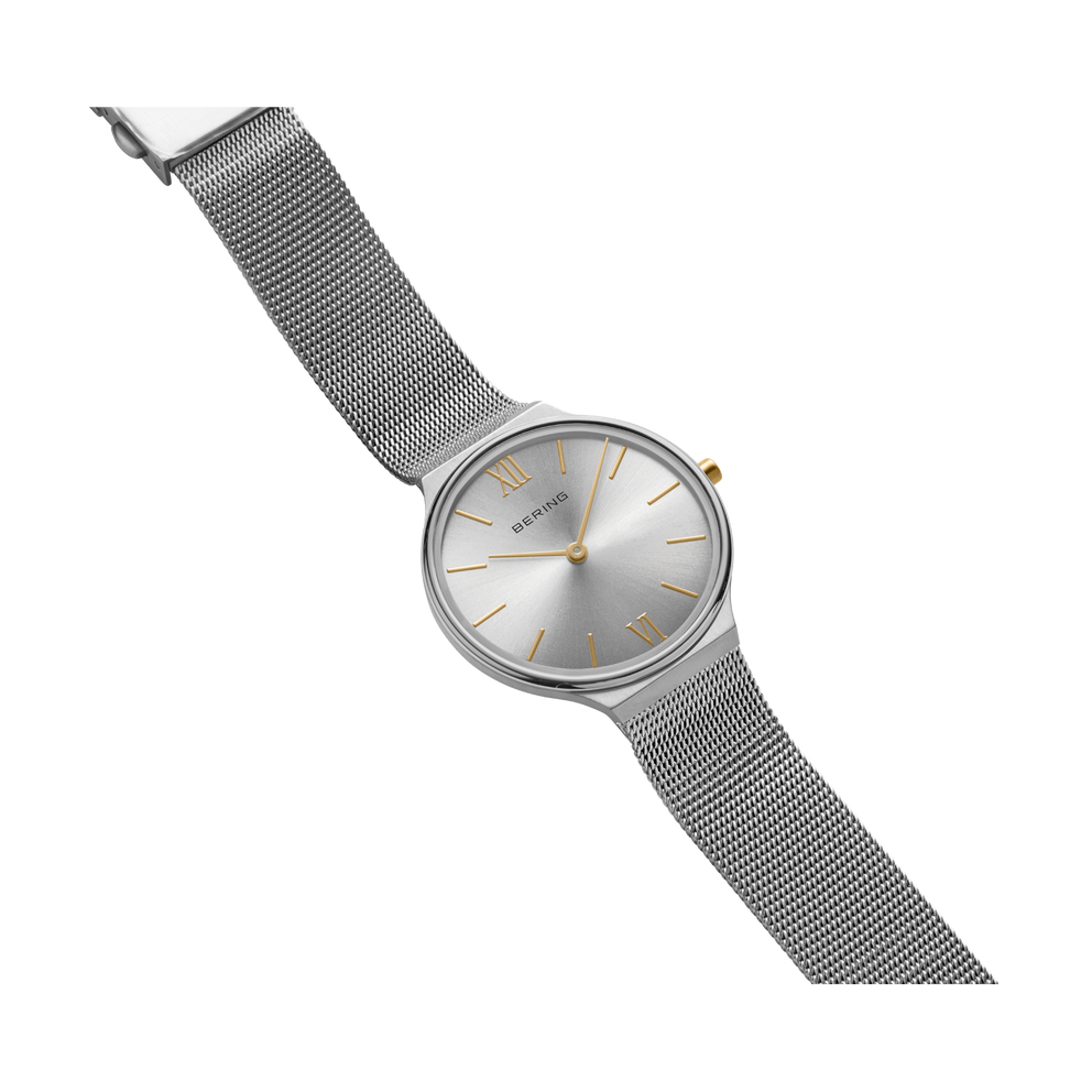 BERING watch with round minimalist dial and gray mesh band shown at angle