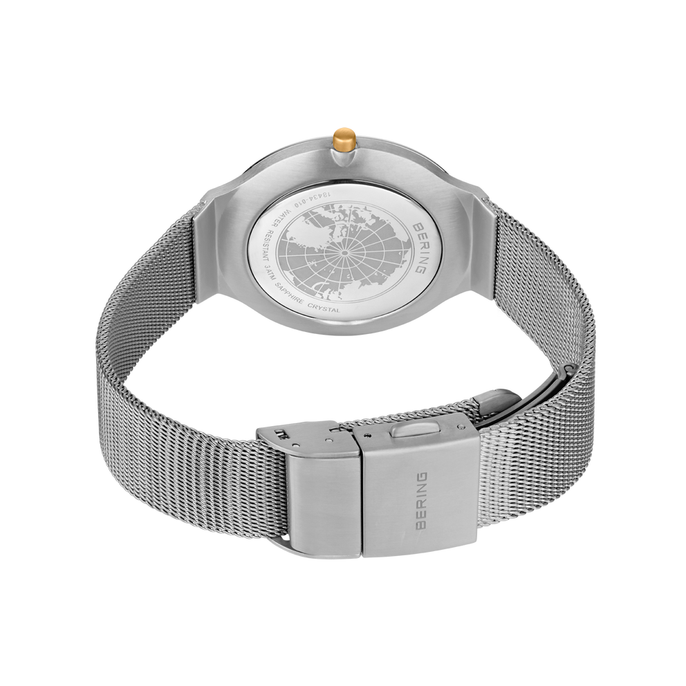 Back view of wristwatch with silver mesh bracelet and rectangular clasp, textured dial visible