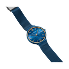 BERING watch with blue dial and gold indices, blue textile strap, angled view.