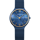 BERING watch with blue dial, Roman numerals, gold accents, and blue mesh band on white background.