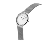 Minimalistische Armbanduhr mit weißem Zifferblatt, schwarzen Zeigern und silbernem Mesh-Armband in Schrägansicht.