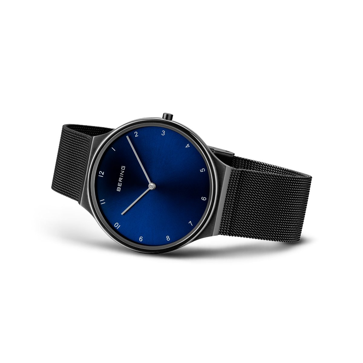 Reloj con esfera azul oscura, agujas minimalistas, cifras árabes y pulsera malla negra visto en ángulo