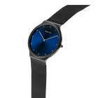 Reloj BERING con esfera azul marino redonda y pulsera de malla negra, vista lateral